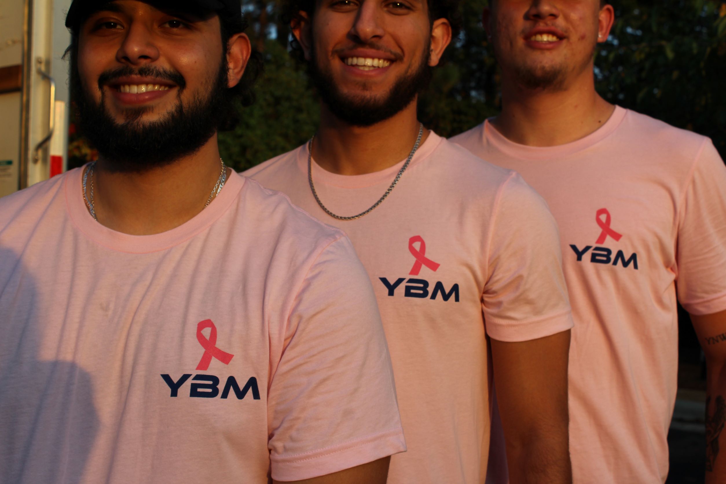 YBM crew leaders showing the breast cancer awareness merch